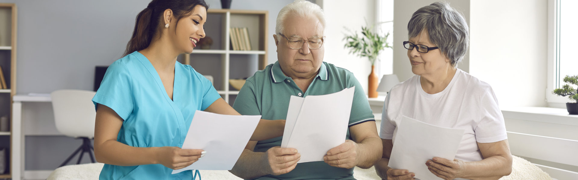 Professional home care nurse helps senior patients fill informed exam consent